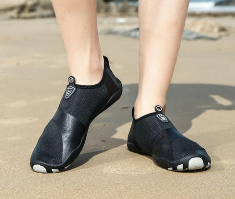Homme avec chaussures de plage Motion Noir d'Aquashoes marchant sur le sable