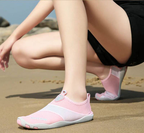 Donna con scarpe da spiaggia Motion Rose d'Aquashoes che marciano sul sabbia