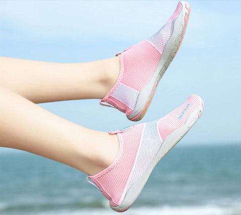 Donna con scarpe da spiaggia Motion Rose d'Aquashoes che marciano sul sabbia