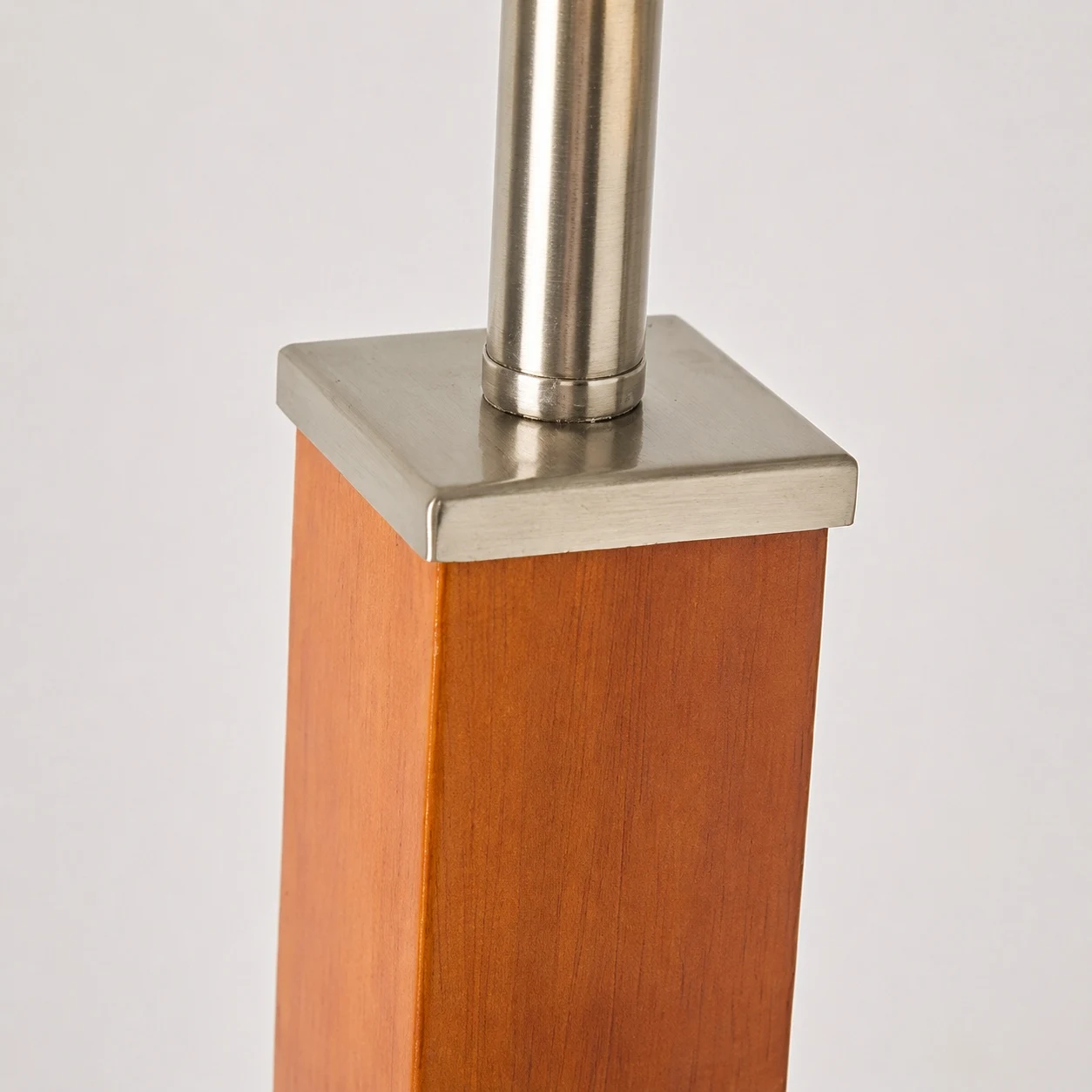 Lámpara de mesa con columna de madera y detalles de níquel pulido.