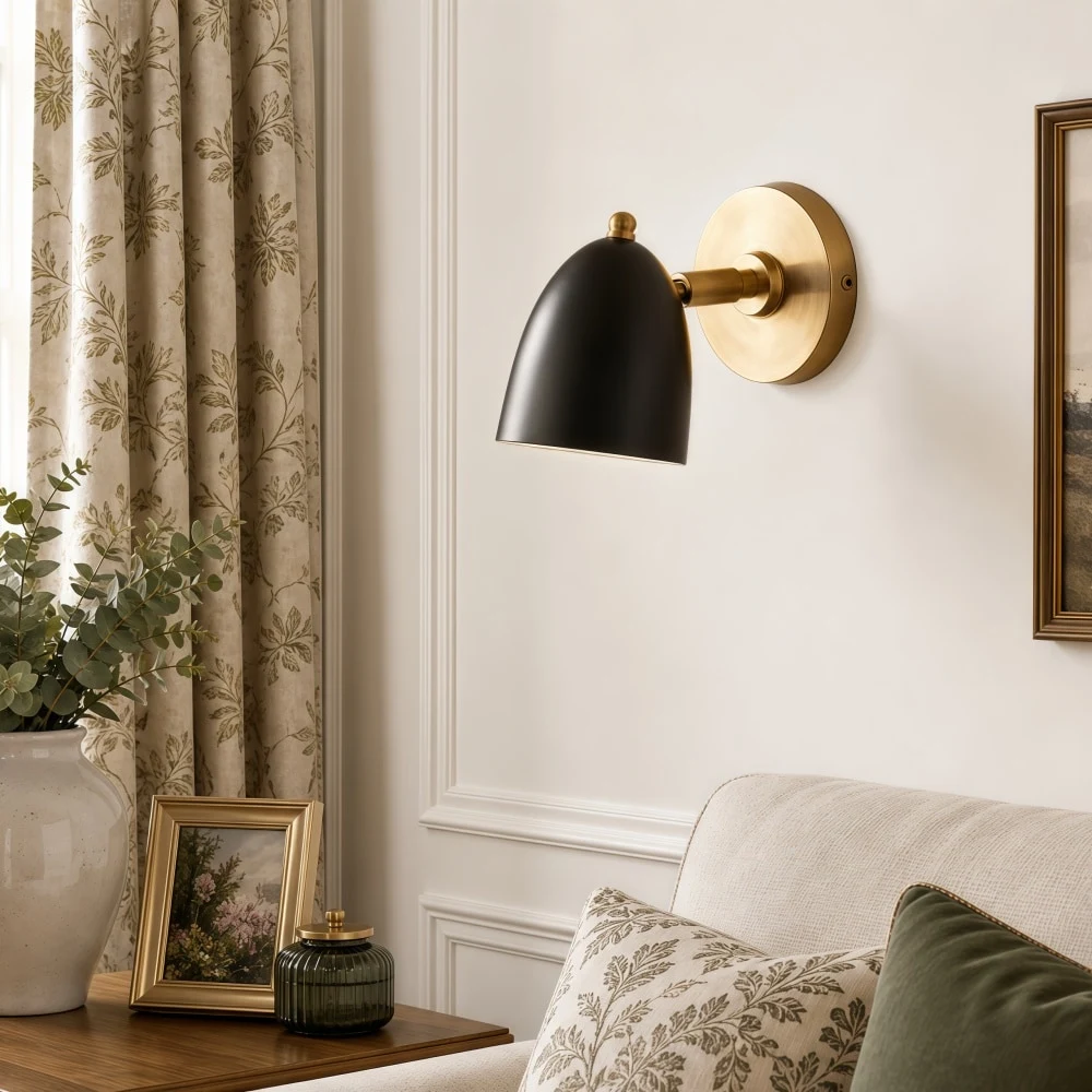Black and gold wall sconce above a styled bedside corner