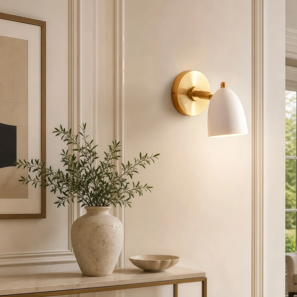 White and gold wall sconce beside artwork
