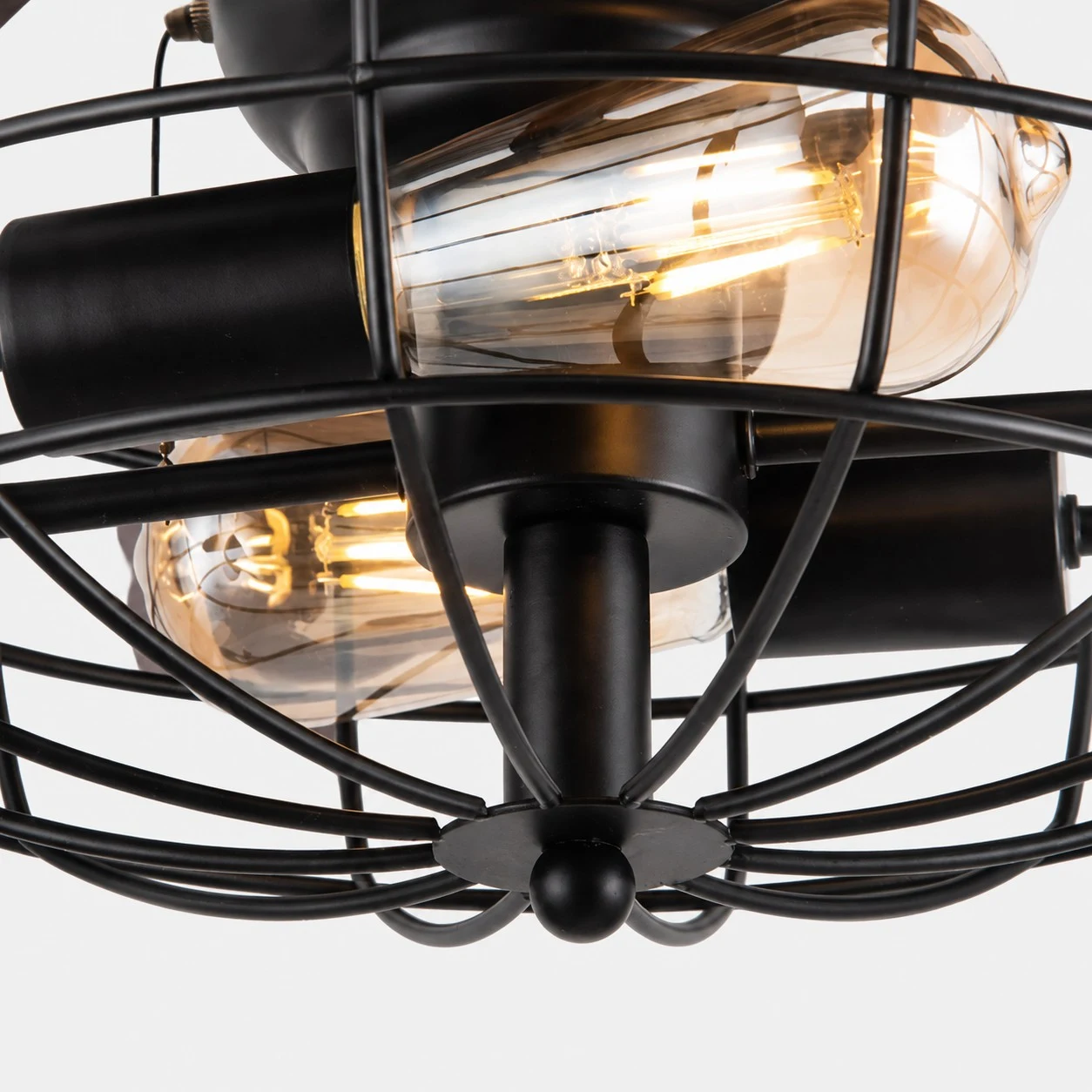 Gros plan sur la structure de l'ampoule protégée par une cage et la lumière chaude